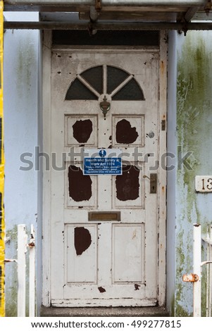 derelict property door with health and safety sign