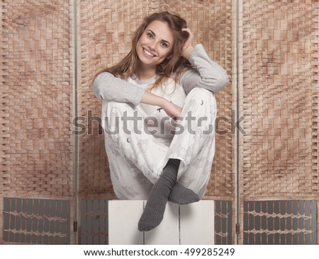 Happy teenage girl in funny pajamas on grey background studio. Funky teenager wearing Pajamas cartoon style 