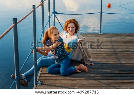 Mother and daughter on the pier, on the banks of rivers, lakes