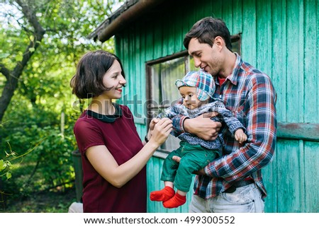 Young family with child posing on the background of an abandoned building