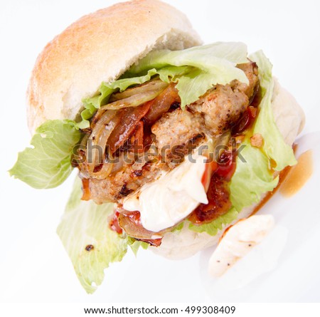 Hamburger with fried onion, tomatoes, iceberg lettuce, mayonnaise and ketchup