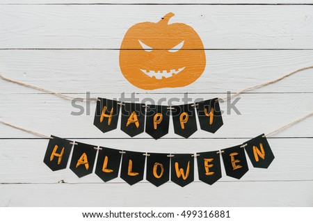 Handwritten happy halloween banner lettering, cut pumpkin on white rustic painted barn wood background