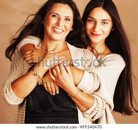 cute pretty teen daughter with mature mother hugging, fashion st