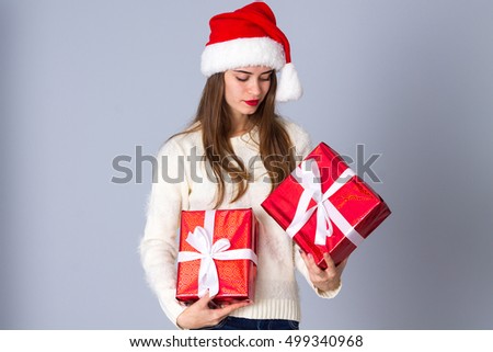 Woman in red christmas hat holding presents