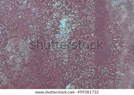 brown metal plate with cracked pale blue and green painted and spots because of time as background, metal wall with rusty spots and cracked paint as texture, toned to color, high quality resolution