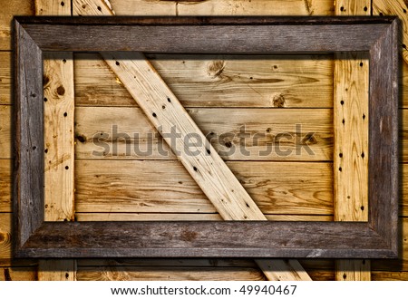 Rustic wood frame against barn door or wood panel background. Blank frame template for your text or image.