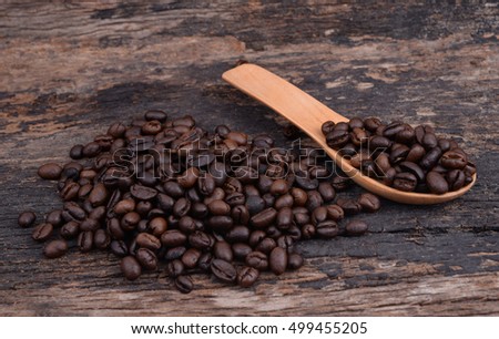 Coffee beans on wood plank with wooden spoon