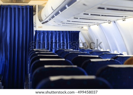 Blue seats and white panel inside airplane