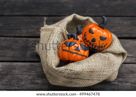 Halloween pumpkin in hessian sack on wooden floor