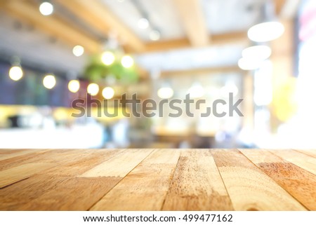 Wood table top in blur cafe interior background - can be used for montage foods or products