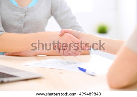 Young business woman shaking hands  after signing contract