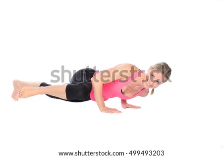 Single woman in tied back hair, pink top and black tights doing abdominal and thigh muscle exercises called spiderman