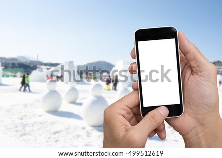 Man hands holding smart phone, tablet over  winter background.