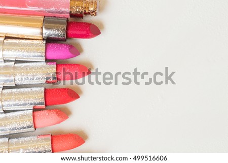Set of wet lipsticks with copy space on beige background close up