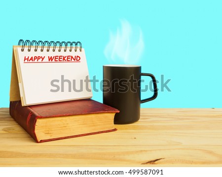 Mug of coffee on wooden floor with old book  and happy weekend note of blue background, happy weekend concept.
