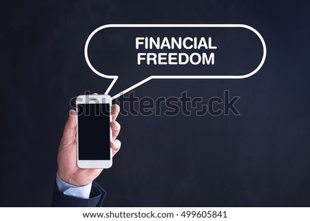 Hand Holding Smartphone with FINANCIAL FREEDOM written speech bubble