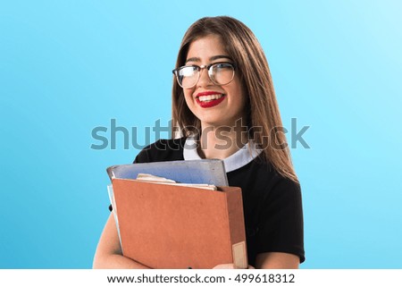 Girl holding several college notes on blue background