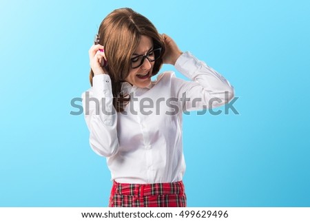 Student girl listening music on blue backgound