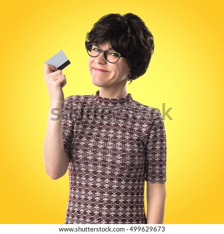 Girl holding a credit card on yellow backgound