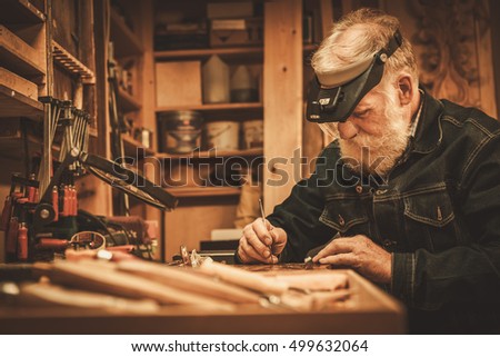 Senior restorer working with antique decor element in his workshop