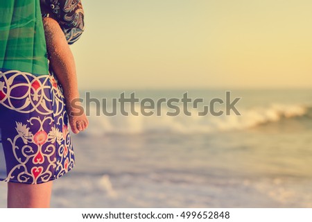Mother and child walking on sandy beach sunset outdoors background