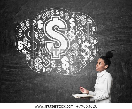 Side view of African American girl with notebook standing near blackboard with dollar cloud sketches. Concept of earning 