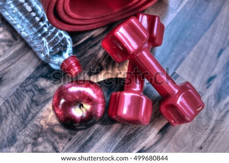 Fitness concept with dumbbells, apple and water