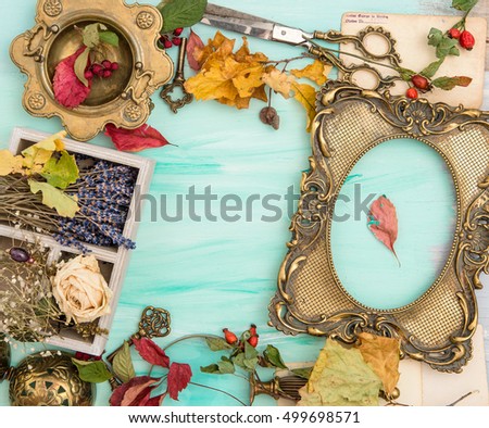 Autumn leaves and golden picture frame over bright wooden background. Scrapbook concept