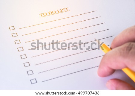 hand with pencil on to do list