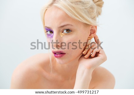 Beauty portrait of cute young woman with blonde hair and creative makeup over white background