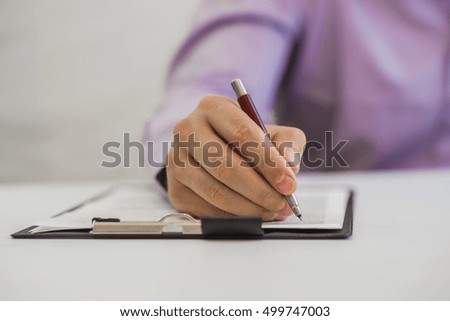 Businessman making notes on the paper in his office