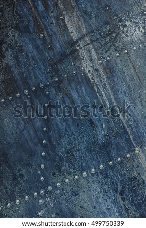 Old aluminum background detail of a military aircraft, surface corrosion. Oxidized metal texture with rivets.