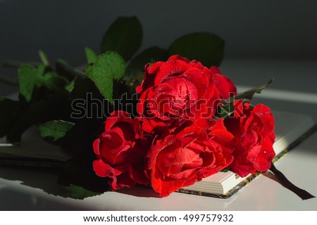 Bouquet of red roses on the notebook. 