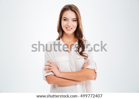 Portrait of a happy woman standing with arms folded isolated on a white background