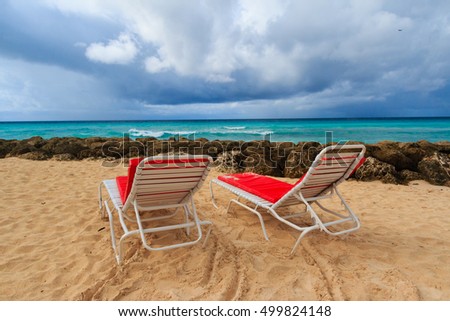 Vacation background.Tropical beach of Barbados with lounging chairs
