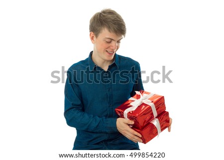 portrait of handsome man with two gifts in his hands looking on it and smiling isolated on white background