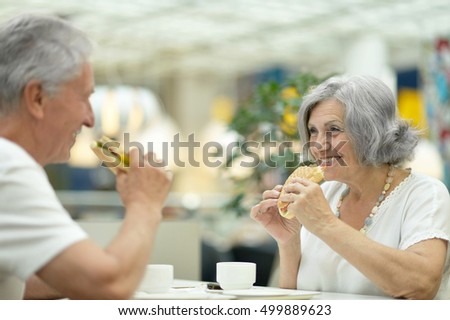 Beautiful elderly couple eating fast food