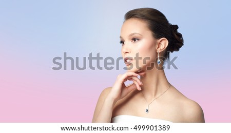 beauty, jewelry, wedding accessories, people and luxury concept - beautiful asian woman or bride with earring and pendant over rose quartz and serenity gradient background