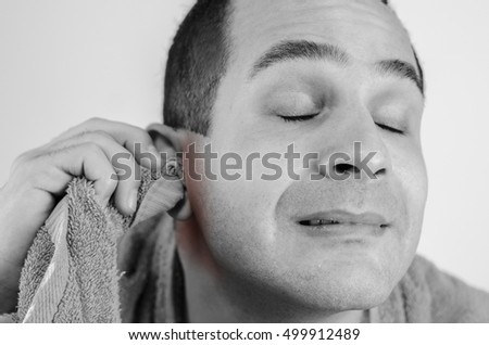 Man holding a towel to his ear. Inflammation of the ear or mumps