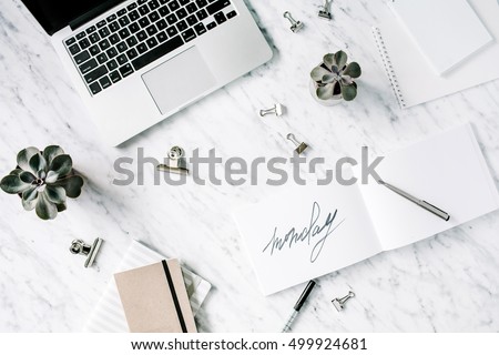 Word monday. Flat lay, top view office table desk. Workspace with laptop, diary, succulent and clips on marble background.