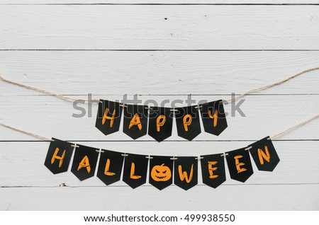 Handwritten happy halloween banner lettering, cut pumpkin on white rustic painted barn wood background. Empty space for copy, text, lettering. Holiday greeting card, postcard template.