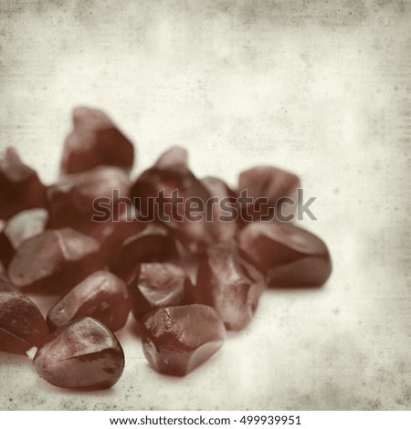 textured old paper background with dark red ripe pomegranate