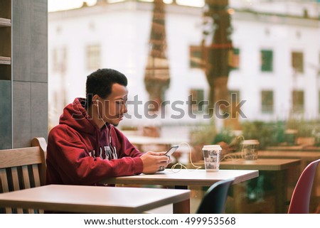 Man hands holding tablet over autumn leaves background
