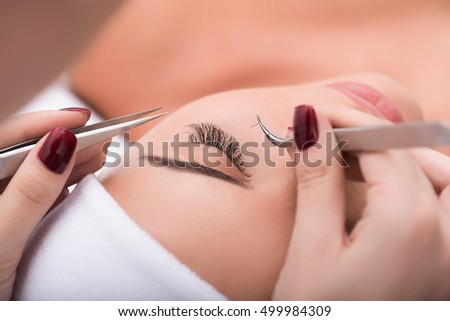 Beautiful young woman during eyelash extension