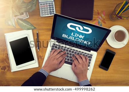 LINK BUILDING Corporate identity mock up on an hardwood desk with laptop, tablet, smartphone and a cup of coffee, man working