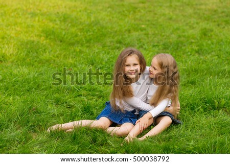 Beautiful girlfriend resting on the nature. Two cute sisters posing in the park