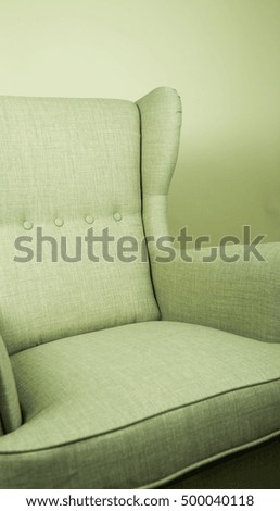Green Upholstered Arm Chair on Same Colored Background