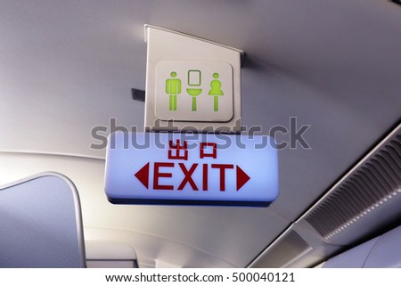 Exit and lavatory sign on the ceiling of the commercial airlines. Selective focus.