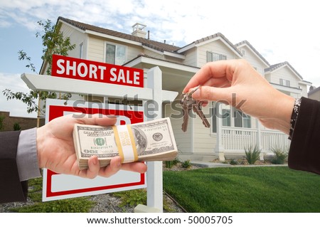 Handing Over Cash For House Keys and Short Sale Real Estate Sign in Front of Home.