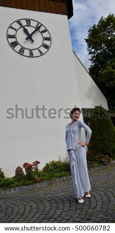 Young woman full-length portrait on church clock background